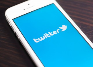 Image of Twitter on phone via Twin Design/Shutterstock