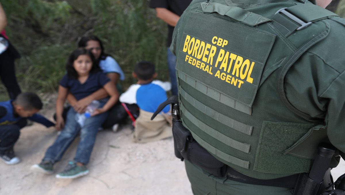 Central American asylum seekers wait as U.S. Border Patrol agents take them into custody on June 12, 2018 near McAllen, Texas. The families were then sent to a U.S. Customs and Border Protection (CBP) processing center for possible separation.