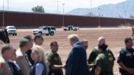 US President Donald Trump speaks with members of the US Customs and Border Patrol as he tours the border wall between the United States and Mexico in Calexico, California on April 5, 2019.