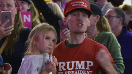A man shouts at journalists as Donald Trump speaks during a rally