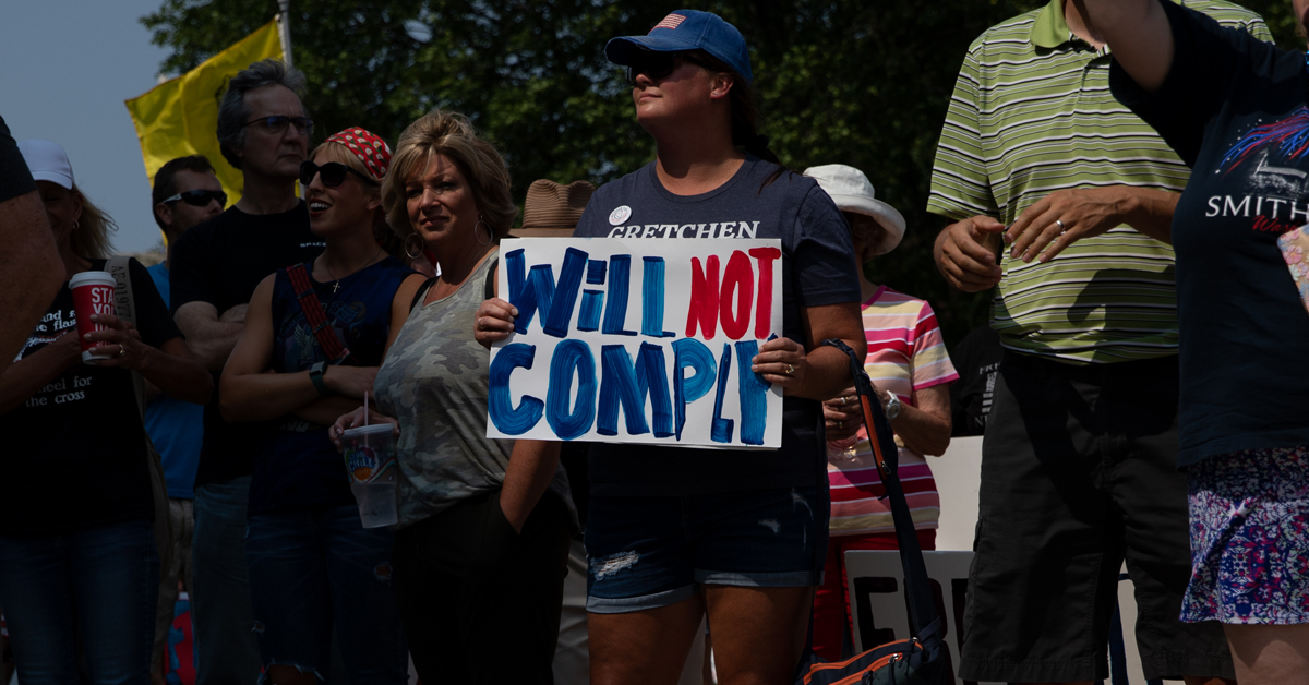 A woman holds a sign reading Will Not Compply as she joins hundreds of other demonstrators gathering to protest against mandated vaccines outside of the Michigan State Capitol on August 6 2021 in Lansing Michigan