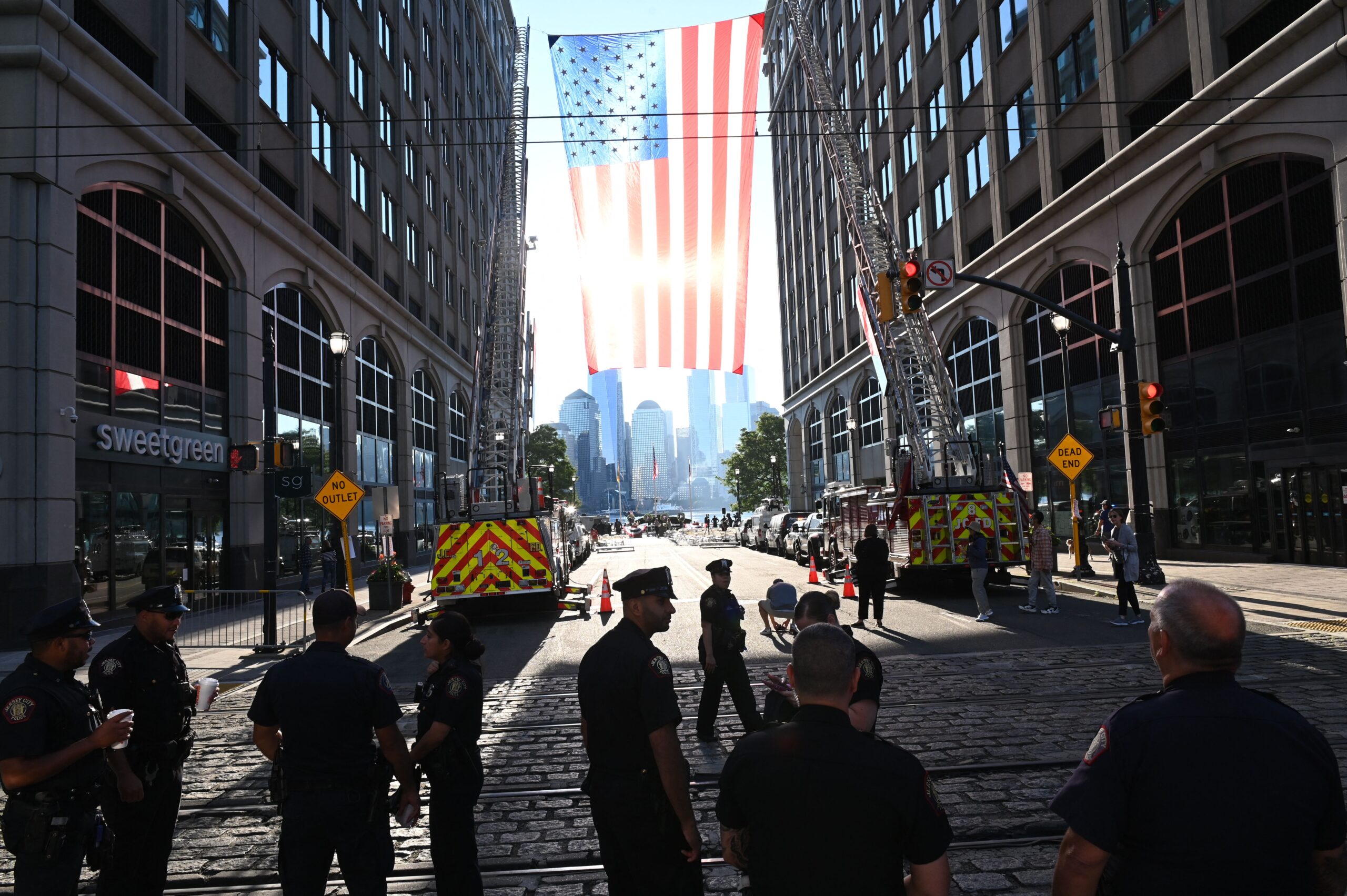 Firefighters from the New Jersey Fire Department march near an oversized American flag hoisted near the Hudson River.