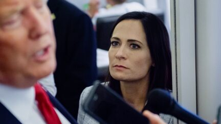 White House Press Secretary Stephanie Grisham listens as US President Donald Trump speaks to the media aboard Air Force One while flying between El Paso, Texas and Joint Base Andrews in Maryland, August 7, 2019.