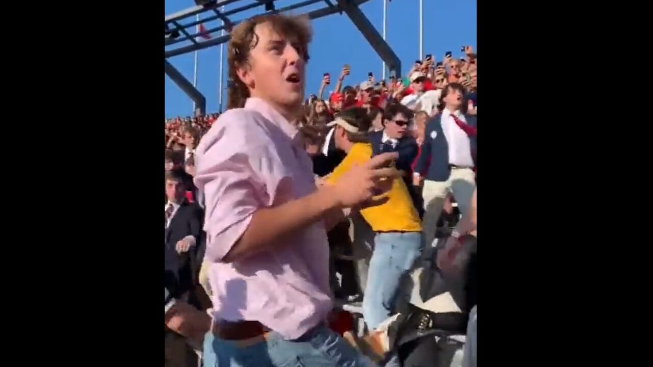 LSU fan protects his sunglasses during crowd fight