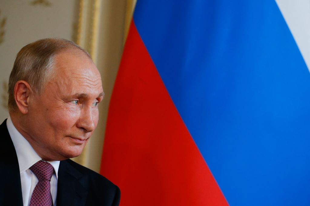 Vladimir Putin in front of the Russian flag