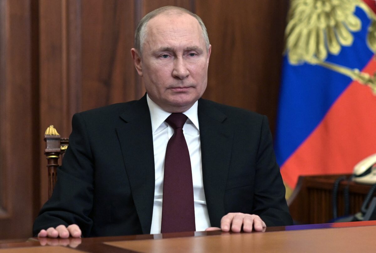 vladimir putin seated at a desk