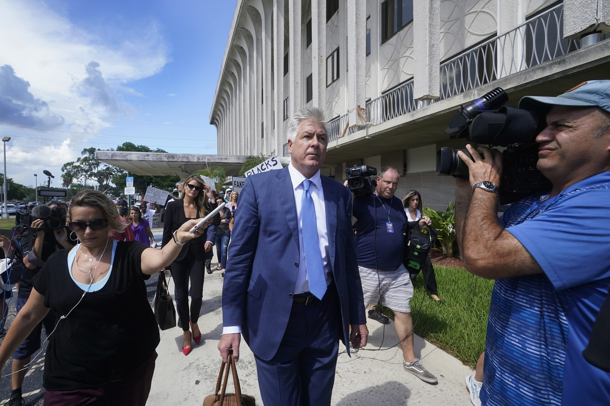 Attorney Evan Corcoran, center, leaves the Paul G. Rogers Federal Building and U.S. Courthouse in West Palm Beach, Fla., Thursday, Sept. 1, 2022. A federal judge has heard arguments on whether to appoint an outside legal expert to review government records seized by the FBI last month in a search of former President Donald Trump's Florida home. There was no immediate ruling after arguments Thursday.