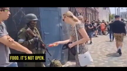Woman giving food to Wagner troop