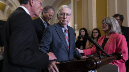 Senate Minority Leader Mitch McConnell, R-Ky., center, is helped by, from left, Sen. John Barrasso, R-Wyo., Sen. John Thune, R-S.D., and Sen. Joni Ernst, R-Iowa, after the 81-year-old GOP leader froze at the microphones as he arrived for a news conference, at the Capitol in Washington, Wednesday, July 26, 2023. McConnell went to his office for a few minutes and returned to speak with reporters.