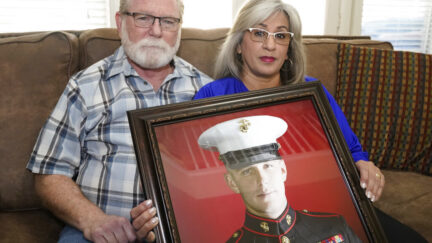 FILE - Joey and Paula Reed pose for a photo with a portrait of their son, Marine veteran and Russian prisoner Trevor Reed, at their home in Fort Worth, Texas, Feb. 15, 2022. Negotiations between the U.S. and Russia led to basketball star Brittney Griner's return to the U.S. on Friday, Dec. 9, 2022, in exchange for notorious arms dealer Viktor Bout. It is the latest in a series of high-profile prisoner swaps involving Americans detained abroad, one of whom was Reed, an American imprisoned in Russia for nearly three years. He was swapped for Konstantin Yaroshenko, a Russian pilot who had been serving a 20-year federal sentence for conspiring to smuggle cocaine into the U.S.