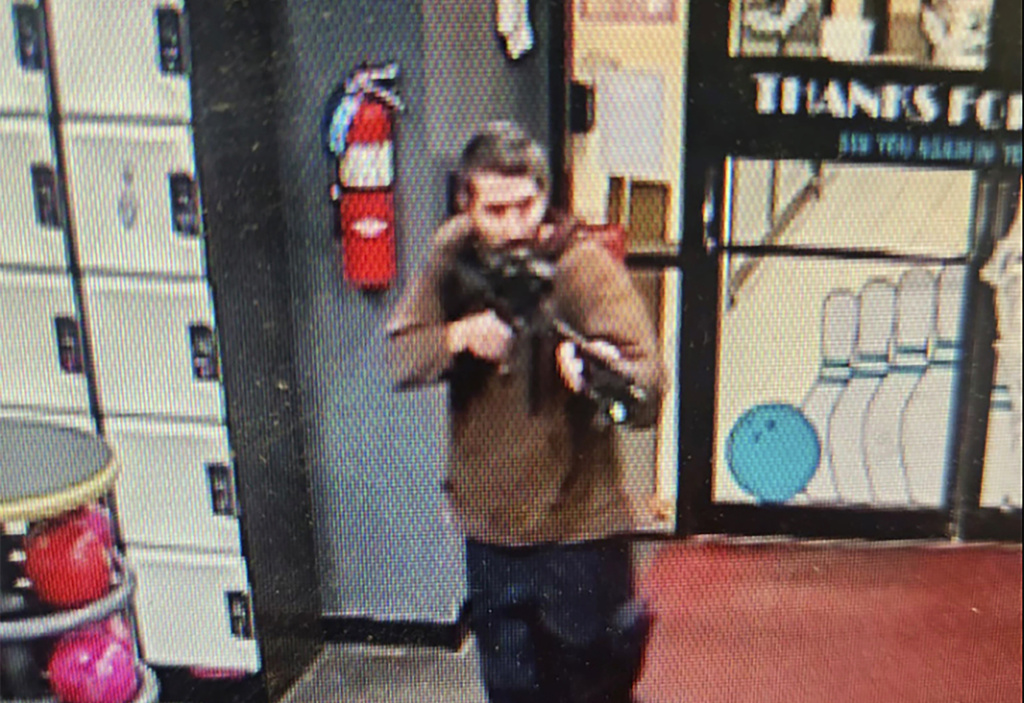 In this image taken from video released by the Androscoggin County Sheriff's Office, an unidentified gunman points a gun while entering Sparetime Recreation in Lewiston, Maine, on Wednesday, Oct. 25, 2023. Maine State Police ordered residents in the state's second-largest city to shelter in place Wednesday night as the suspect remains at large.