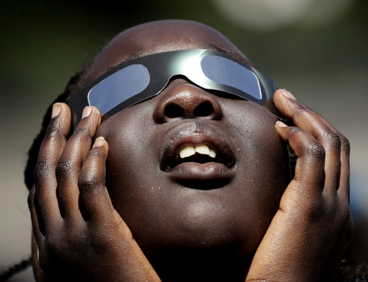 Poureal Long, a fourth grader at Clardy Elementary School in Kansas City, Mo., practices the proper use of eclipse glasses in anticipation of 2017's solar eclipse.