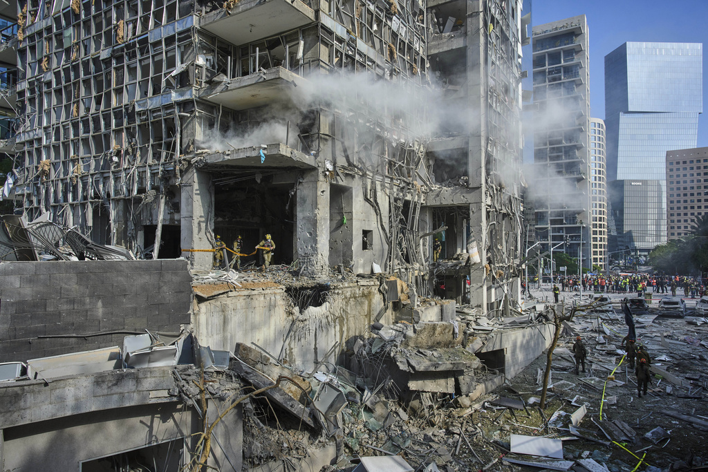 Rescue workers and military personnel inspect the site of a direct hit from an Iranian missile strike in Ramat Gan, Israel, Thursday, June 19, 2025. 