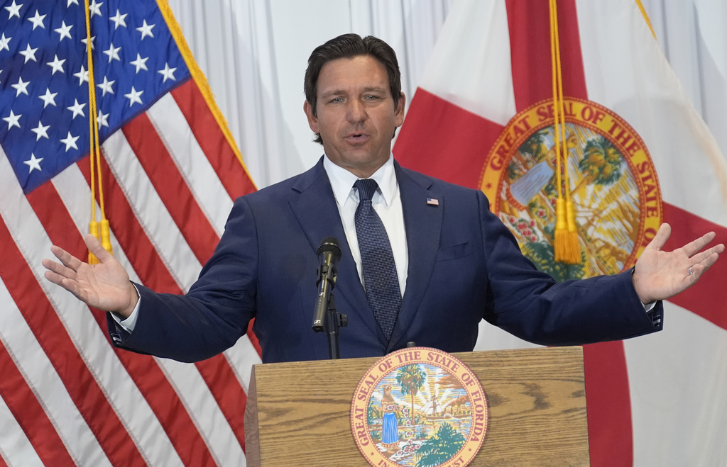 Ron DeSantis in front of U.S. and Florida flags