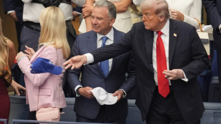 President Donald Trump tosses a hat during the US Open tennis men's singles final Sunday, Sept. 7, 2025, in Flushing, N.Y.