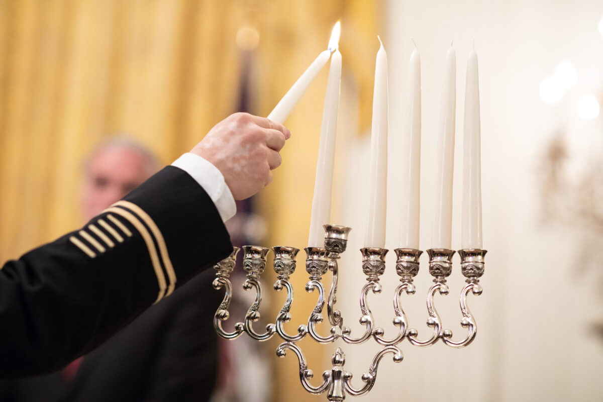 U.S. Army LTC Rabbi Shmuel Felzenberg lights the Menorah during a Hanukkah reception Thursday, Dec. 6, 2018, in the East Room of the White House.