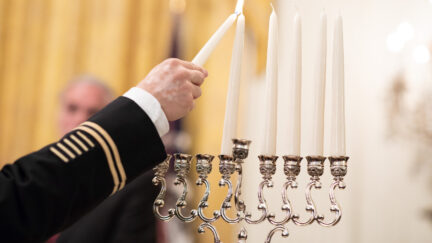 U.S. Army LTC Rabbi Shmuel Felzenberg lights the Menorah during a Hanukkah reception Thursday, Dec. 6, 2018, in the East Room of the White House.