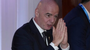 gianni infantino with his hands in a prayer pose in front of his face
