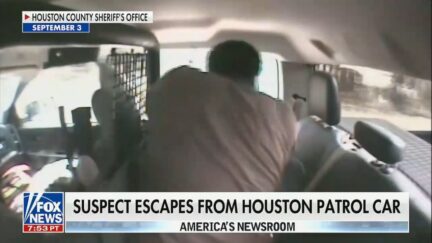 large man trying to escape via patrol car window