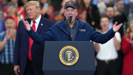 Daniel S. Sullivan at podium at trump rally with trump behind him
