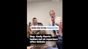 andy harris berrating a reporter while being surrounded by reporters