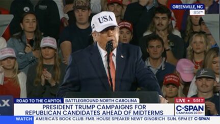 trump in a white hat with crowd behind him at rally on oct. 20 2026