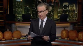 maher holding a paper and looking up